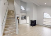 Thumbnail 42 of 43 - a living room with a staircase and a fireplace and white walls and floors