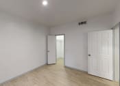 Thumbnail 28 of 43 - the living room and bedroom of an apartment with white walls and wood flooring