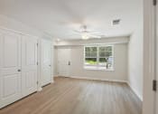 Thumbnail 22 of 39 - an empty living room with a ceiling fan and a window