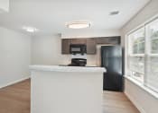 Thumbnail 27 of 39 - a kitchen with a white counter top and a black refrigerator