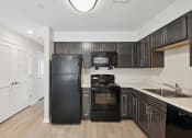 Thumbnail 19 of 39 - a kitchen with black appliances and dark wood cabinets