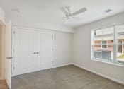 Thumbnail 24 of 39 - an empty bedroom with a ceiling fan and a window
