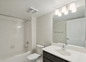 Thumbnail 25 of 39 - a bathroom with a sink toilet and shower and a mirror