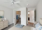 Thumbnail 17 of 19 - a bedroom with a bed and closet and a ceiling fan