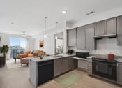Thumbnail 1 of 14 - a kitchen with an island and a living room with a couch