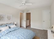 Thumbnail 12 of 39 - a bedroom with a blue and white bed and a ceiling fan