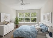 Thumbnail 11 of 39 - a bedroom with a bed and a ceiling fan