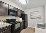 Thumbnail 5 of 19 - a kitchen with black appliances and a sink and black refrigerator