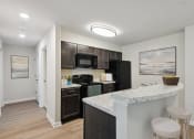 Thumbnail 4 of 19 - a kitchen with black appliances and a counter with two stools