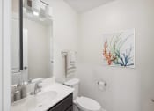 Thumbnail 17 of 39 - a bathroom with a sink and a toilet and a mirror