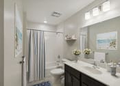 Thumbnail 9 of 19 - a bathroom with a shower toilet and sink and a mirror