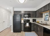 Thumbnail 4 of 39 - a kitchen with black appliances and dark wood cabinets