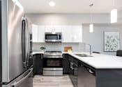 Thumbnail 3 of 18 - a modern kitchen with stainless steel appliances and a white counter top