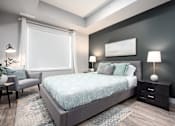 Thumbnail 6 of 18 - a bedroom with a bed and a chair and a window