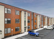 Thumbnail 16 of 30 - a row of apartment buildings with cars parked in front of them