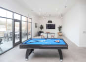 Thumbnail 1 of 30 - an apartment clubhouse with a tv, pool table, and chairs