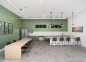 Thumbnail 3 of 30 - an apartment clubhouse kitchen with island, chairs, and refridgerator