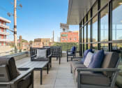 Thumbnail 13 of 26 - a balcony with couches and chairs and a baseball field in the background