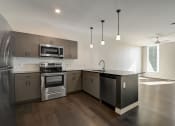 Thumbnail 16 of 26 - a kitchen with stainless steel appliances and an island with a black countertop