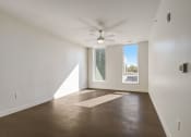 Thumbnail 18 of 26 - a living room with white walls and a large window