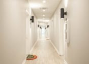 Thumbnail 13 of 28 - a long hallway with white walls and white floors and white doors