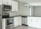 Thumbnail 19 of 28 - a white kitchen with stainless steel appliances and white cabinets