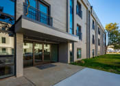 Thumbnail 9 of 28 - the entrance to a building with a sidewalk and glass doors