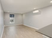 Thumbnail 20 of 28 - a living room with white walls and wood flooring and a window