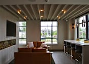 Thumbnail 6 of 31 - A living room with a couch and a bar area.