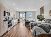Thumbnail 1 of 16 - a bedroom with a bed and a kitchen and a living room