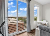 Thumbnail 13 of 16 - a living room with sliding glass doors and a balcony with a view