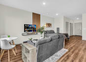 Thumbnail 3 of 16 - a living room with a couch and a table and a tv