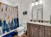 Thumbnail 15 of 16 - a bathroom with a toilet sink and shower and a mirror