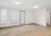 Thumbnail 21 of 31 - A room with wooden flooring and white walls.