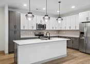 Thumbnail 19 of 31 - A modern kitchen with a white island and stainless steel appliances.