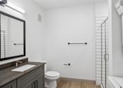 Thumbnail 31 of 31 - A white bathroom with a toilet, sink, and a shower.