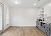 Thumbnail 29 of 31 - A kitchen with white cabinets and a microwave.