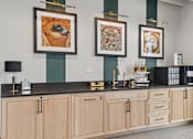 Thumbnail 7 of 31 - A kitchen with a black counter top and wooden cabinets.