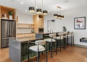 Thumbnail 14 of 31 - A modern kitchen with a bar area and stools.