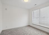 Thumbnail 22 of 31 - A room with a window covered by white blinds.