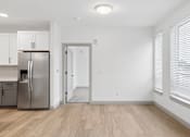 Thumbnail 20 of 31 - A kitchen with a refrigerator, cabinets, and a doorway leading to another room.