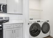 Thumbnail 26 of 26 - A white kitchen with a black fridge, microwave, and dishwasher.