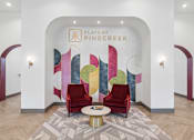 Thumbnail 4 of 26 - A lobby with a white wall and a painting of a tree.