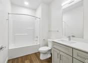 Thumbnail 25 of 26 - A white bathroom with a toilet, sink, and shower.