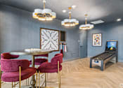 Thumbnail 8 of 26 - A room with a round table and chairs with a TV in the corner.