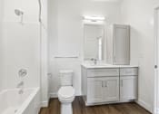 Thumbnail 19 of 26 - A white bathroom with a toilet, sink, and bathtub.