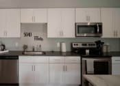 Thumbnail 25 of 28 - view of a kitchen with white cabinets and stainless steel appliances