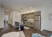 Thumbnail 11 of 30 - A modern kitchen with stainless steel appliances and a marble island.