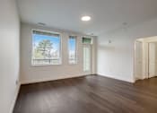 Thumbnail 19 of 30 - A room with wooden floors and two windows.