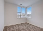 Thumbnail 20 of 30 - A room with a carpeted floor and a window with blinds.